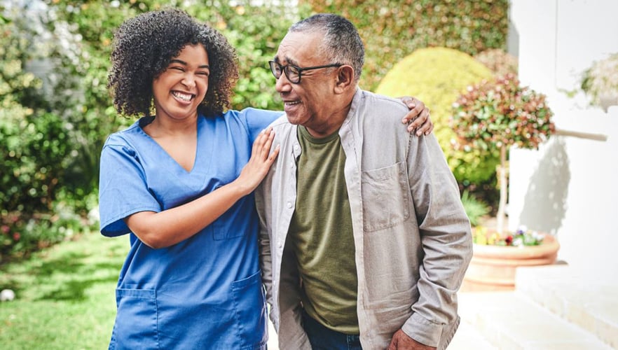 an older African American man and his nurse go for an assisted walk outside. Assisted living blog header